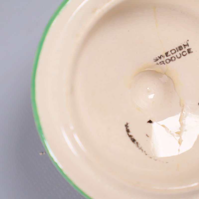 Närbild på lock med spricka och Gustavberg-stämpel