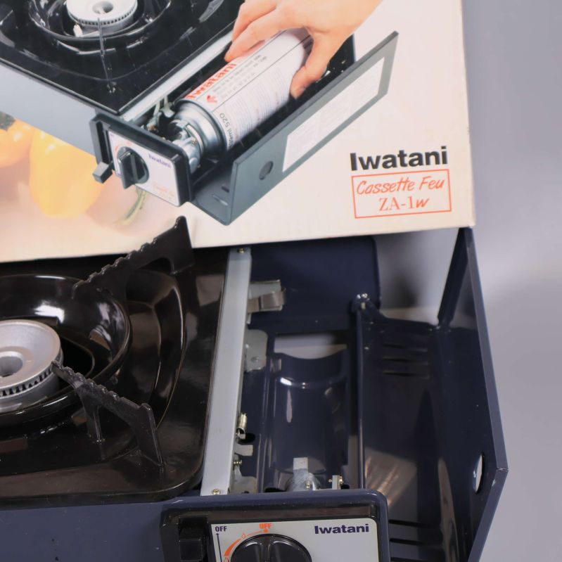 Närbild av gasspis och kartongens produktnamn