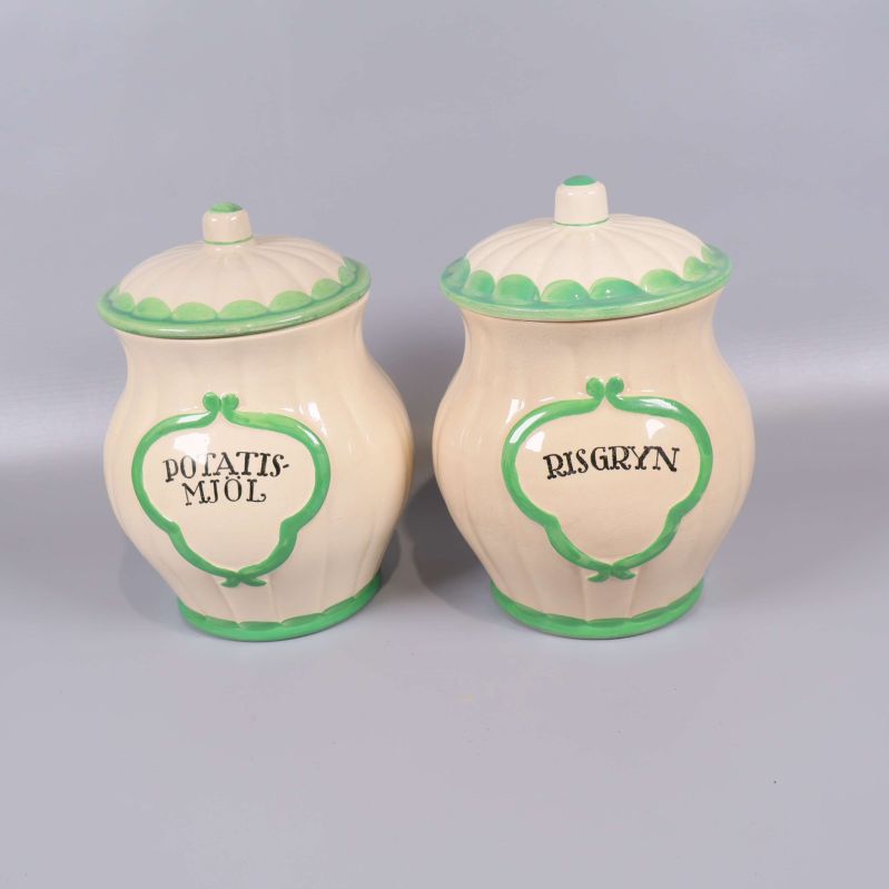 Två förvaringsburkar med grön kant och text Potatismjöl och Risgryn