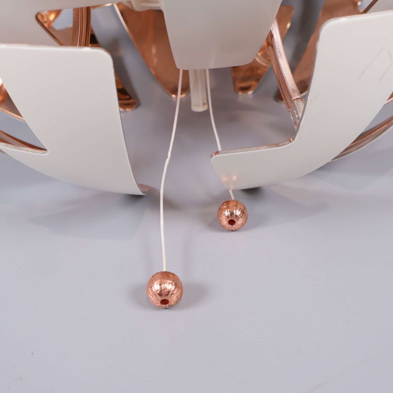 Två dragreglage med kopparfärgade kulor under lampan