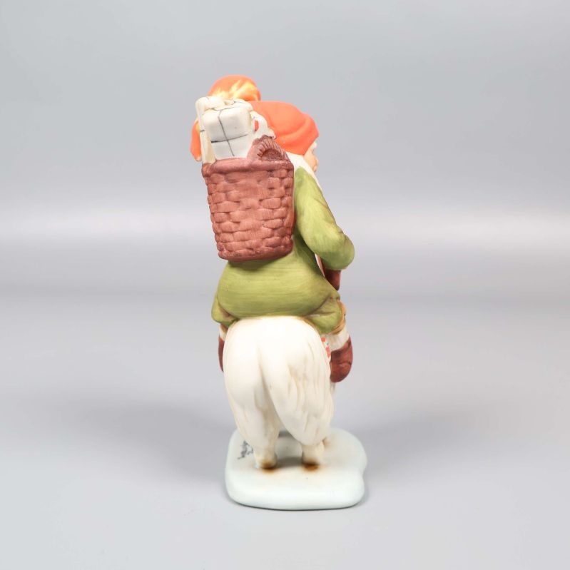 Tomtefigur sedd bakifrån visar korg och luva