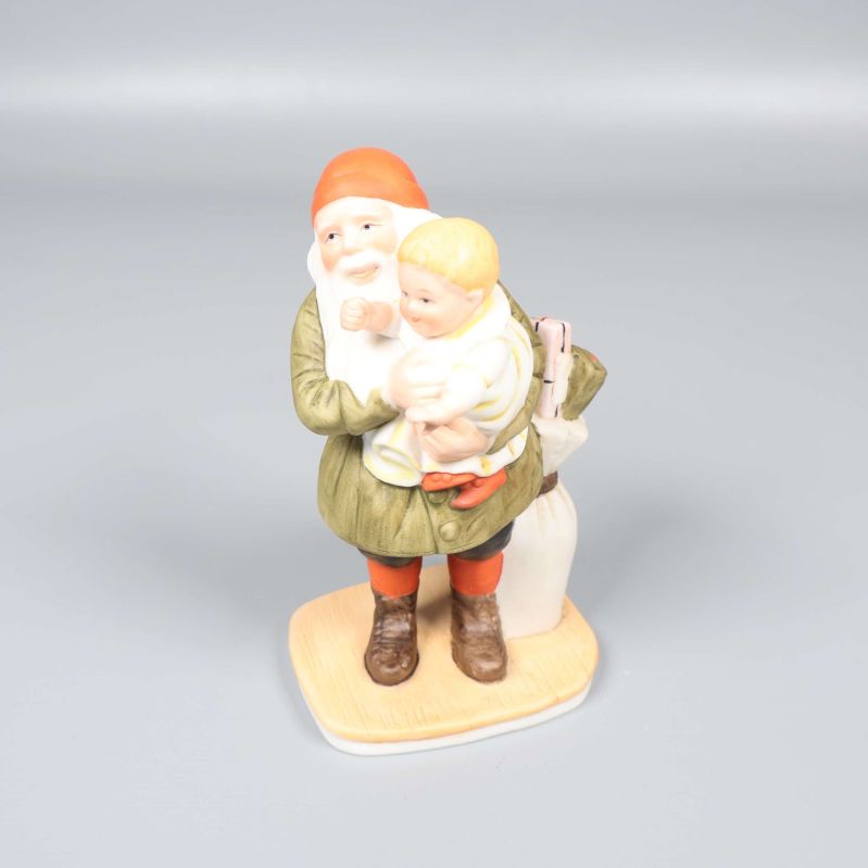 Porslinsfigur visar tomte som håller barn