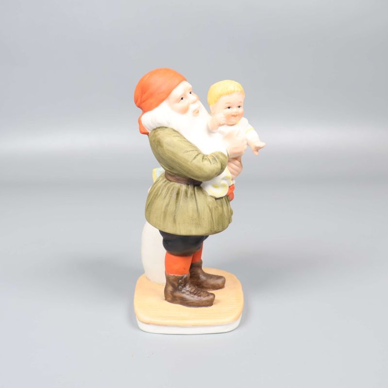 Sida av porslinsfigur med tomte och barn