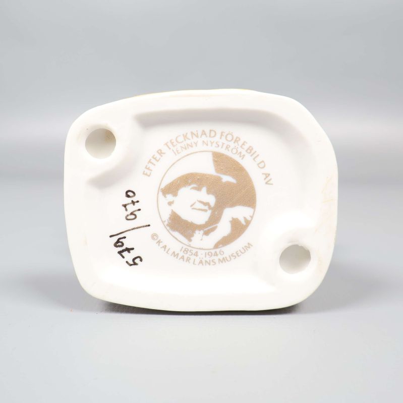 Botten av porslinsfigur med märkning efter Jenny Nyström