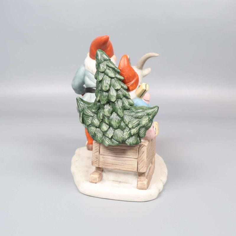 Baksida av tomtefiguren med gran och släde