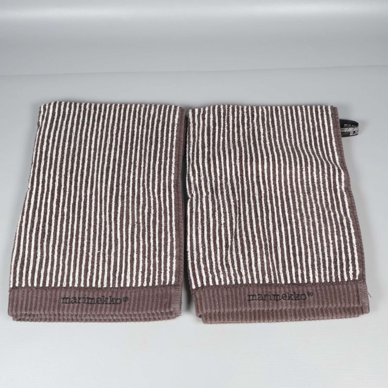 Två vikta randiga handdukar i brunt och vitt