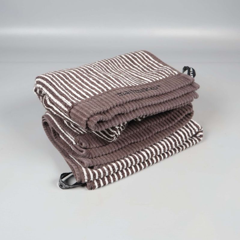 Två vikta handdukar med Marimekko-logga på sidan