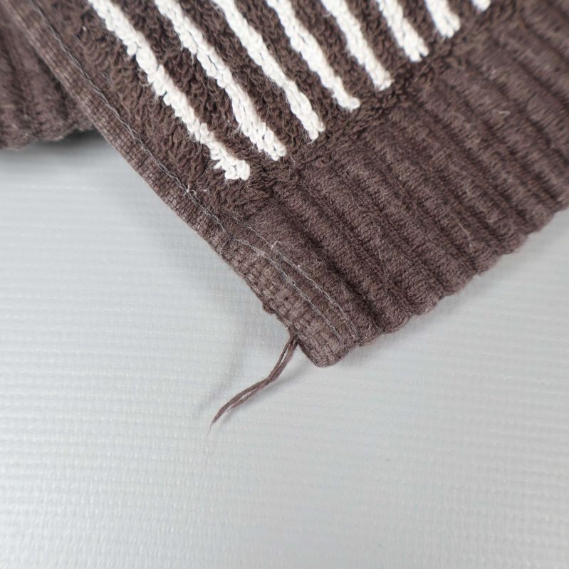 Närbild på handdukens kant och en lös trådände
