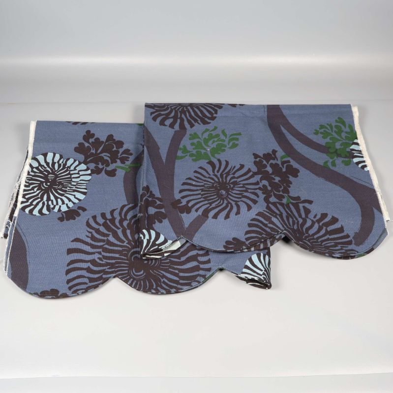 Två gardinkappor med blå och bruna blommor hopvikta