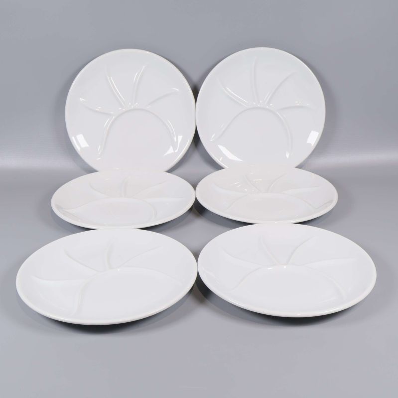 Sex vita tallrikar med flera fack i en halvcirkel