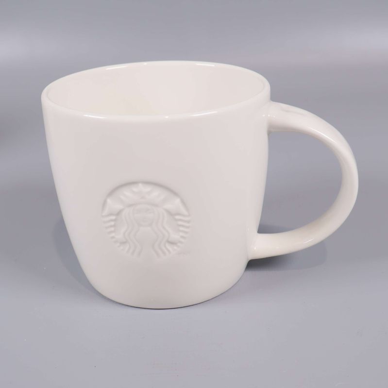 Närbild på vit mugg med Starbucks-relief