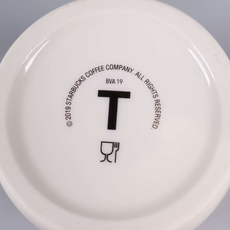 Närbild av muggbotten med Starbucks-logotyp och copyright