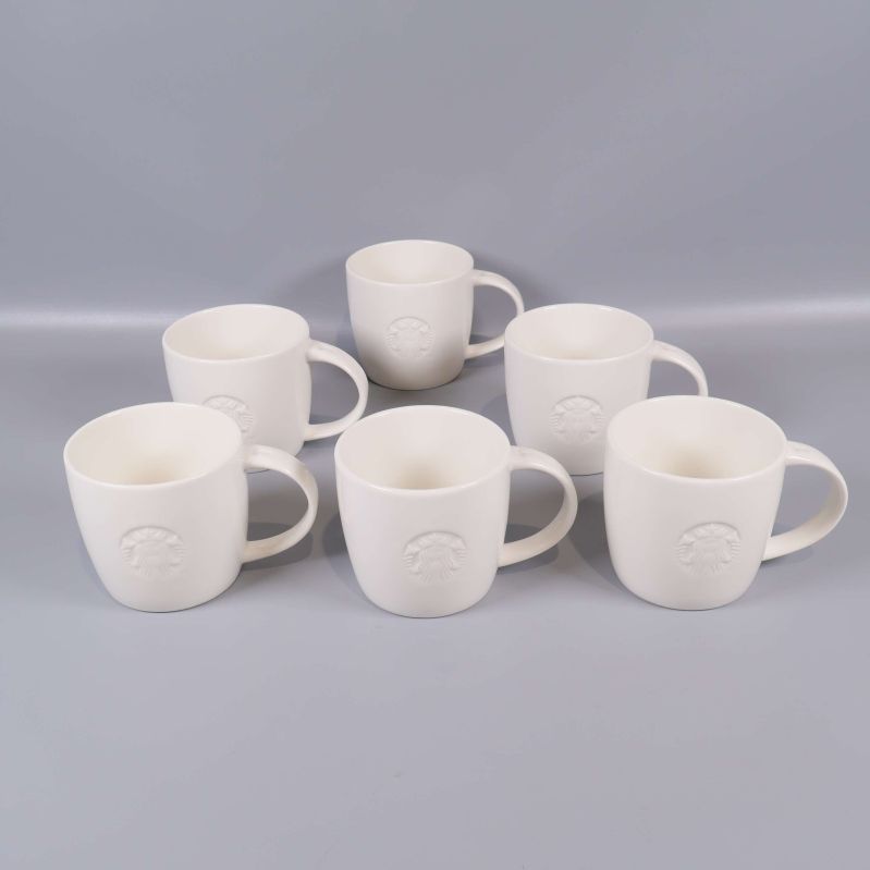 Sex vita muggar uppställda mot grå bakgrund