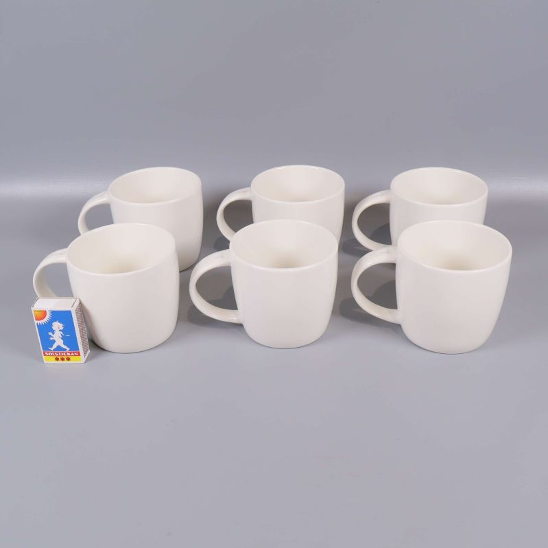 Sex vita muggar varav en med tändsticksask för storleksreferens