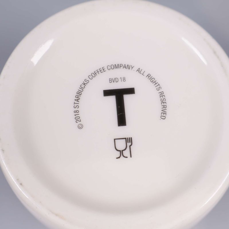Botten av vit Starbucks-mugg med tryckt märkning