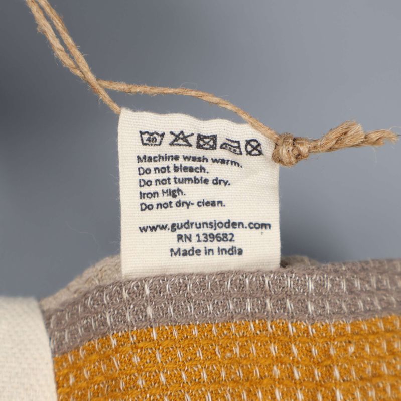 Tvättrådetikett och tillverkningsinformation på tyg