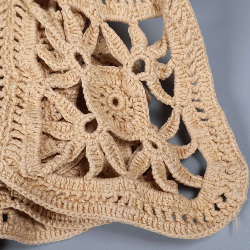 Närbild på virkat rutmönster i beige garn