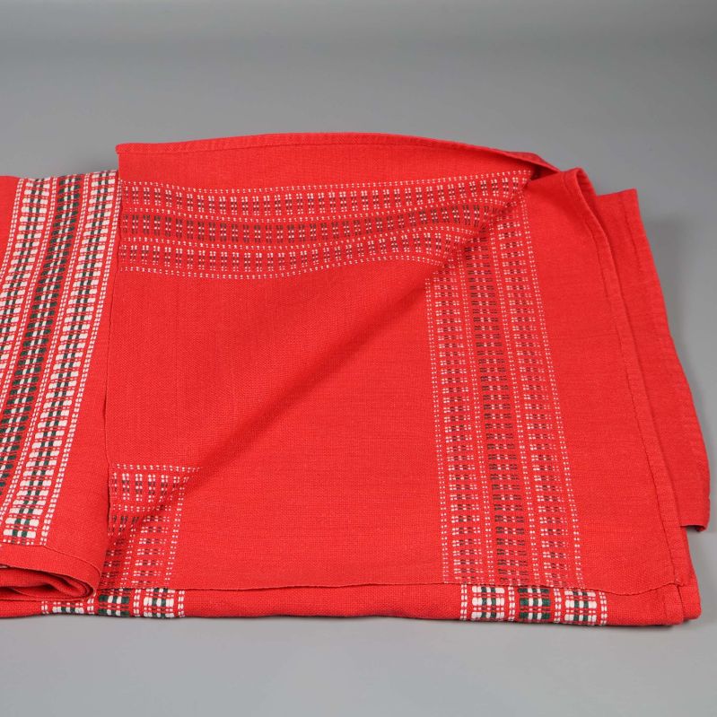 Röd duk halvt utfälld med tydliga mönster