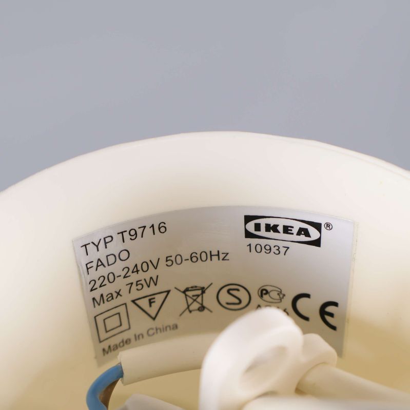 Inuti lampans fäste med Ikeas FADO-etikett och elinformation