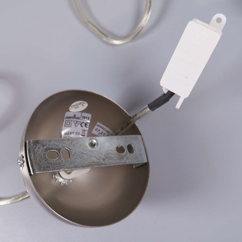 Metallfäste och etiketter inuti fästet på lampan