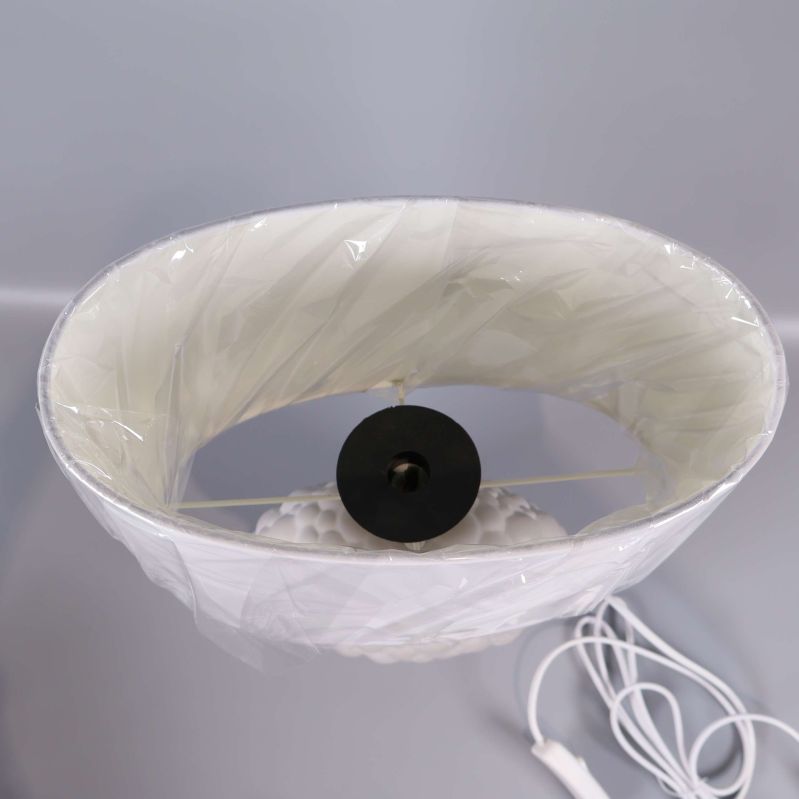 Övre vy av lampskärm i vitt plastskydd med insida i metall