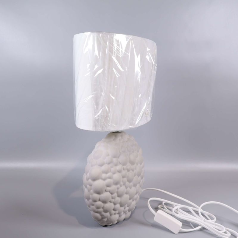 Sidosyn på vit bordslampa med mönster och vit sladd