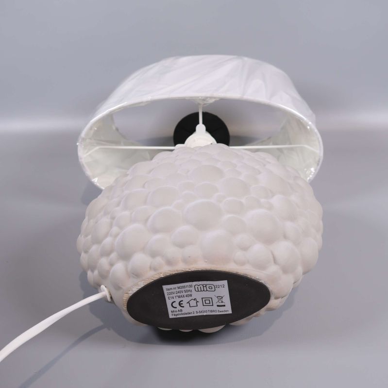 Lampans botten med etikett och sladd synlig mot grå bakgrund