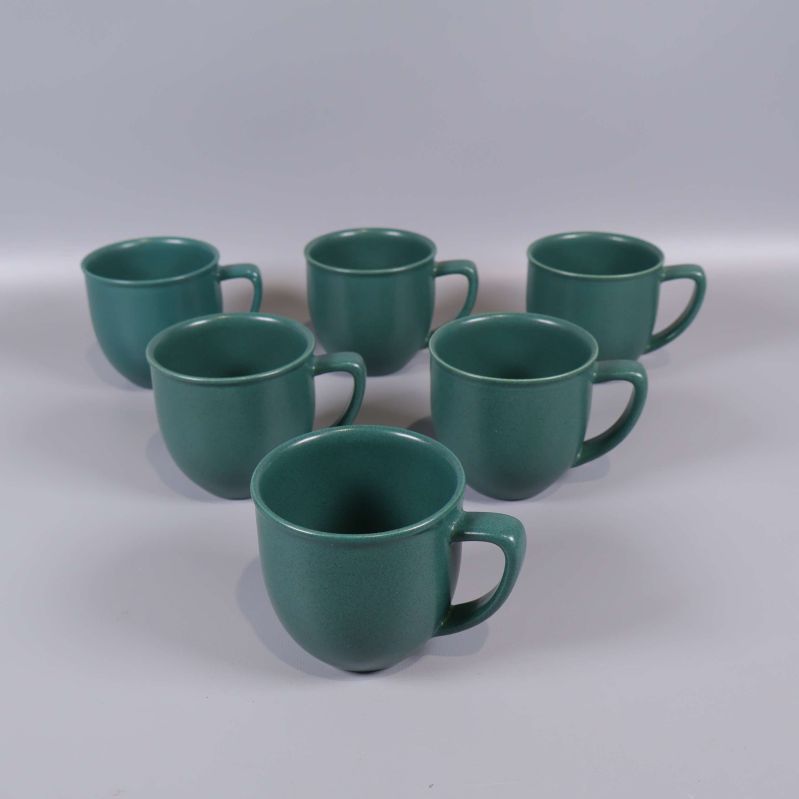 Sex gröna kaffekoppar i grupp mot ljus bakgrund