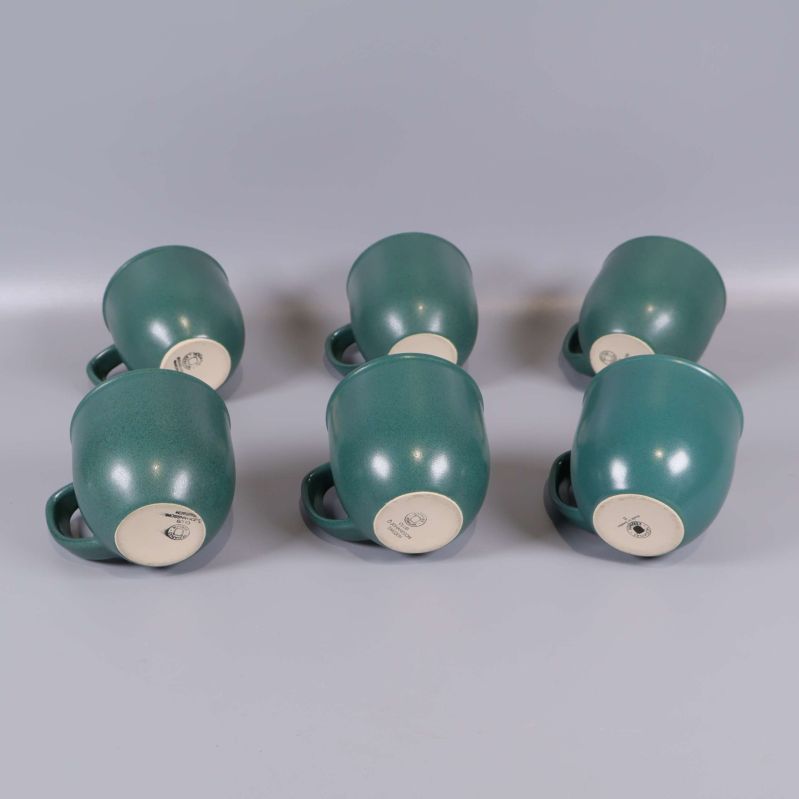 Sex gröna kaffekoppar visade underifrån för att visa botten