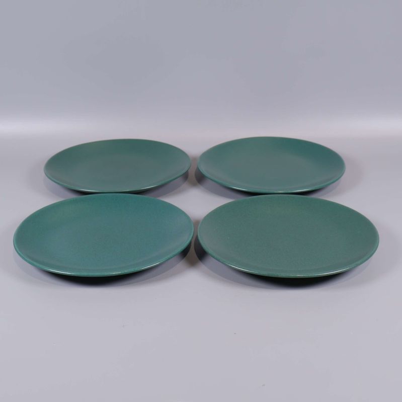 Fyra runda mörkgrön keramikassietter uppifrån