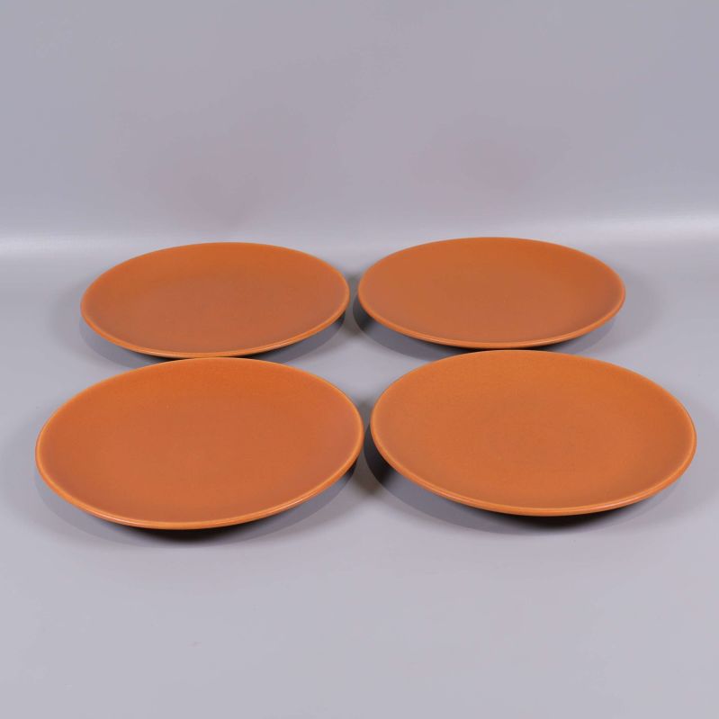 Fyra orangea keramikassietter i grupp mot grå bakgrund