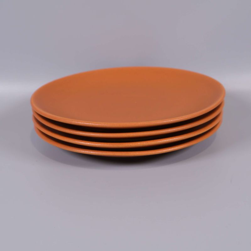 Fyra staplade orangea keramikassietter från sidan