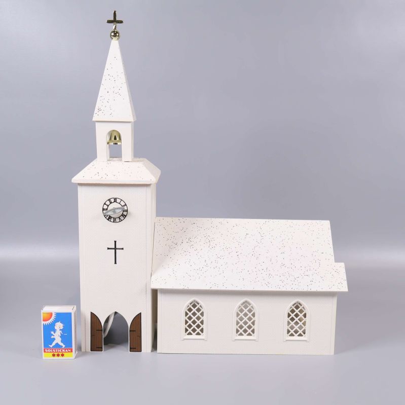 Vit ljuslykta kyrka placerad med tändsticksask