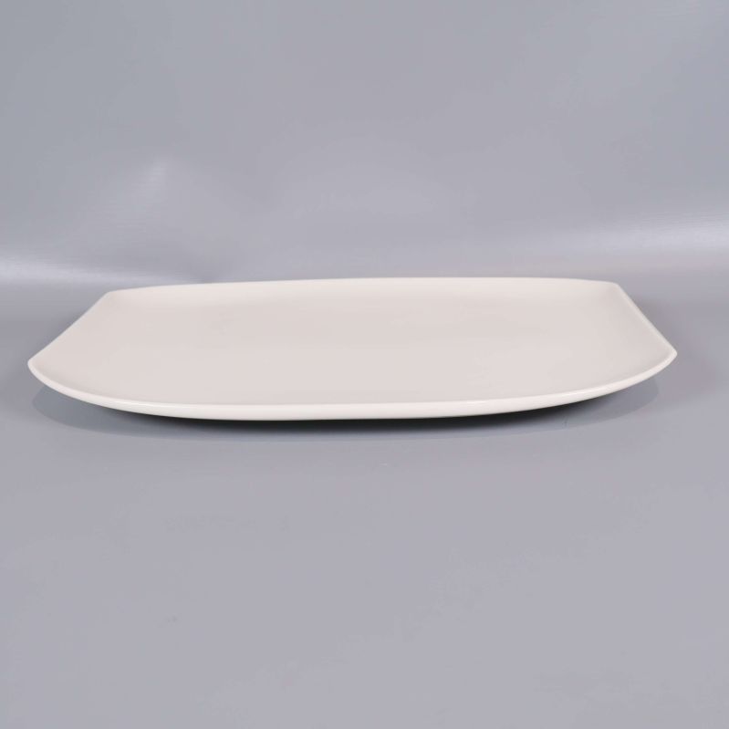 En rektangulär vit tallrik sett från sidan
