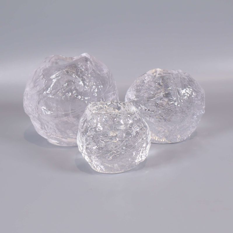 Tre isliknande ljuslyktor i glas på rad