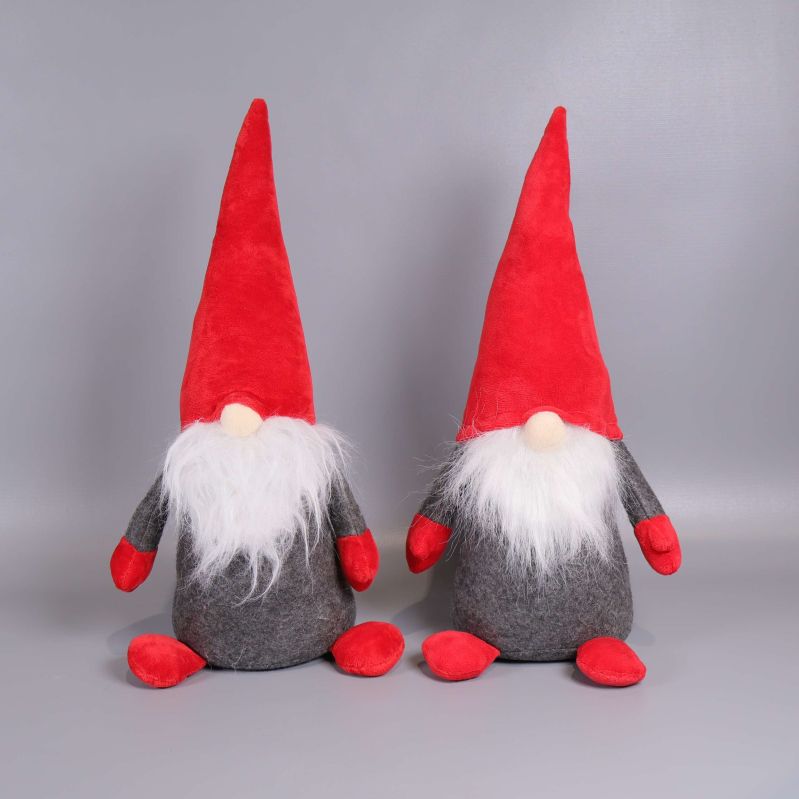 Framifrån vy på två tomtedockor med vita skägg och röda luvor