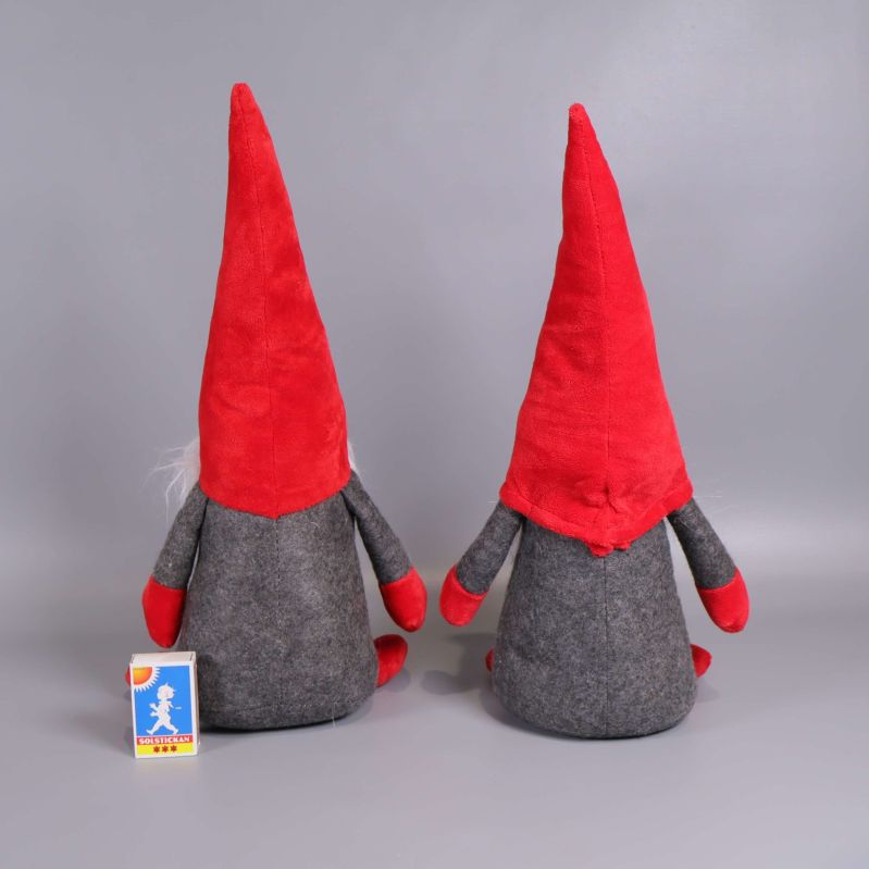 Baksidan av tomtedockor med röda luvor, jämte tändsticksask för storleksjämförelse