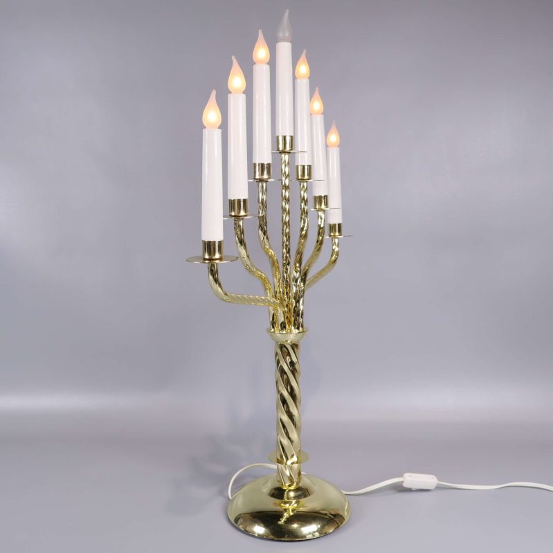 Sidovy av sjuarmad elektrisk mässingsljusstake med tända ljus