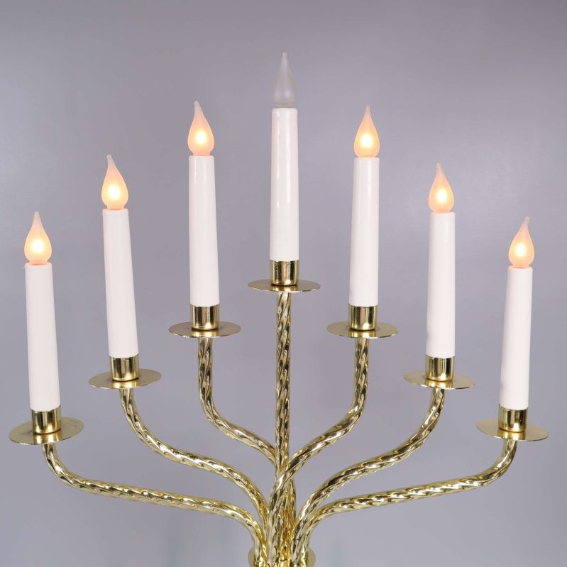 Närbild på sju vita elektriska ljus i mässingshållare