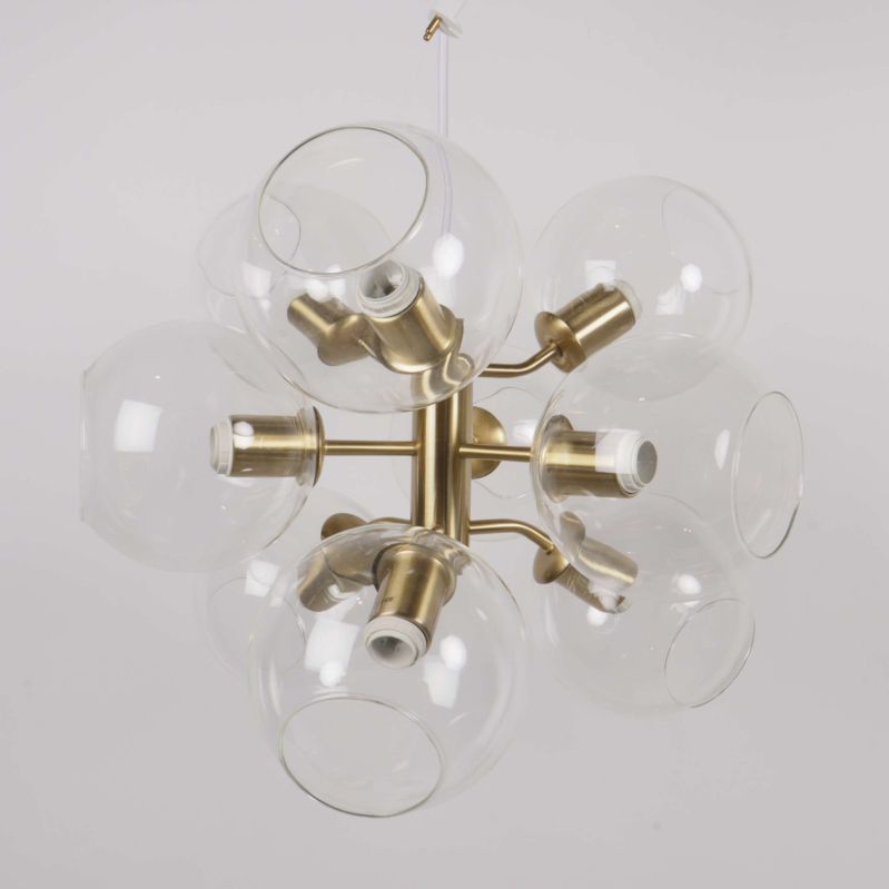 Närbild på taklampans globformade glasskärmar samt mässingsfärgade armar