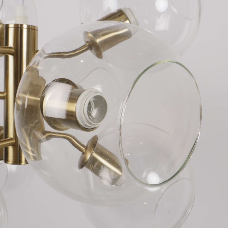 Närbild på lampans glaskupa och fästpunkt av mässingsfärgad metall