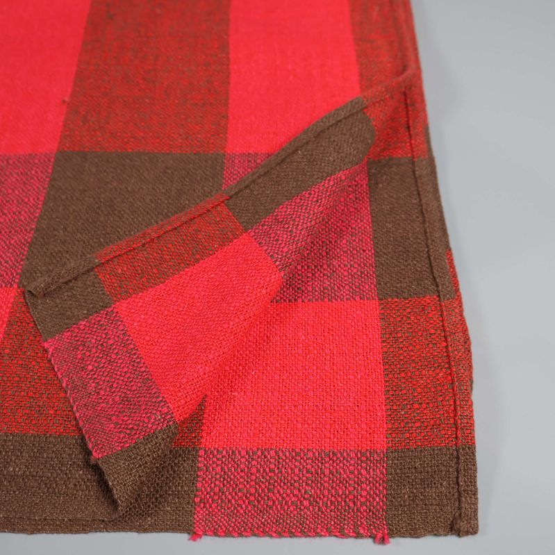 Hörn av rutig duk i rött och brunt