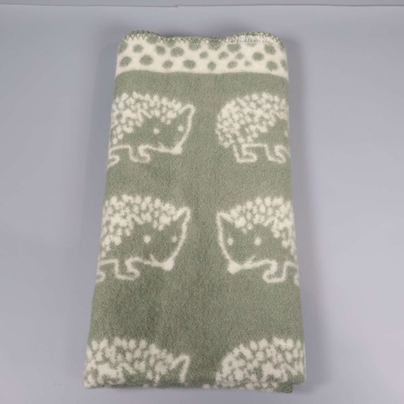 Sammanklippt barnfilt med grönt och vitt igelkottsmotiv