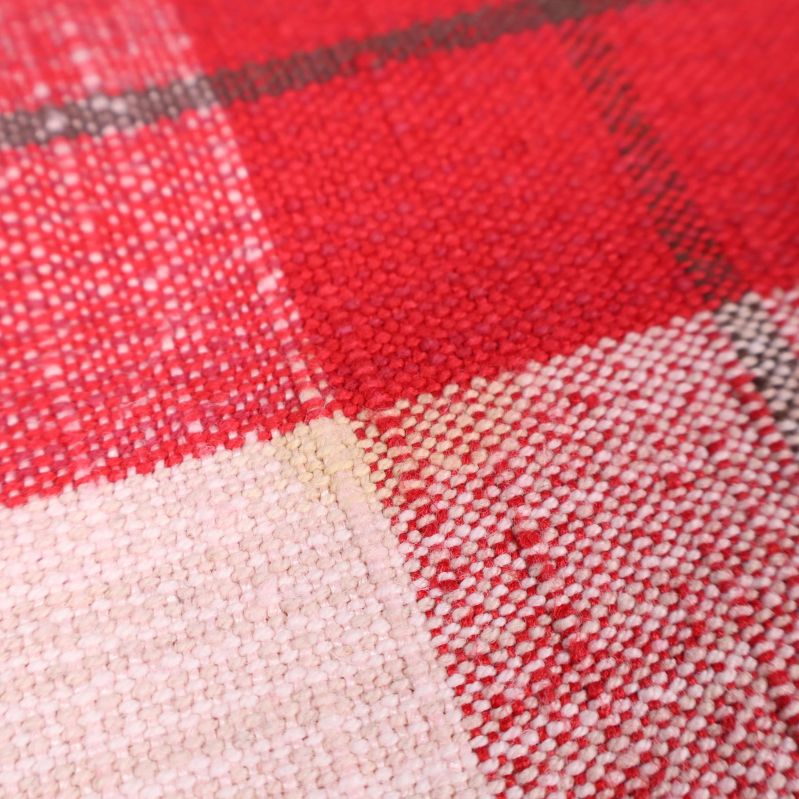 Närbild på fläck i rutigt tyg i rött och vitt