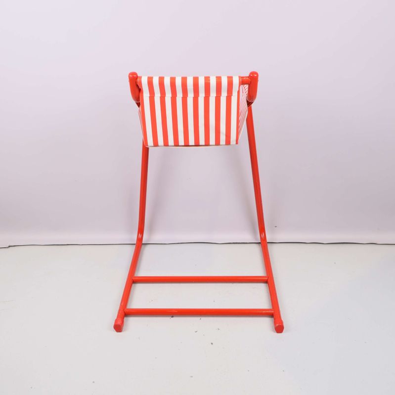 Baksidan på barnstol med röda detaljer och randig rygg