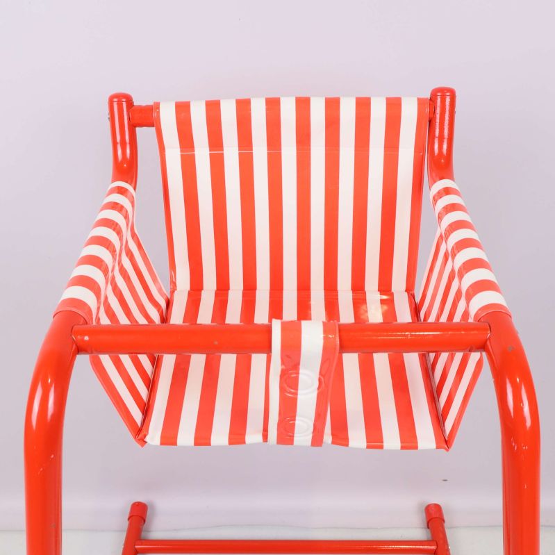 Närbild på randig sits i rött och vitt samt röda armar