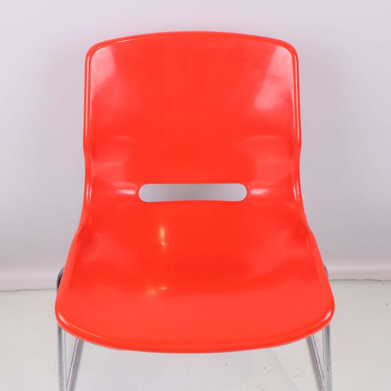 Närbild på stolens röda sits och rygg