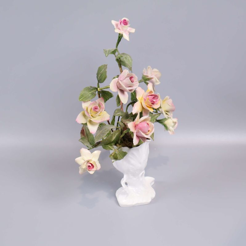 Porslinsvas med konstblommor sedd snett framifrån