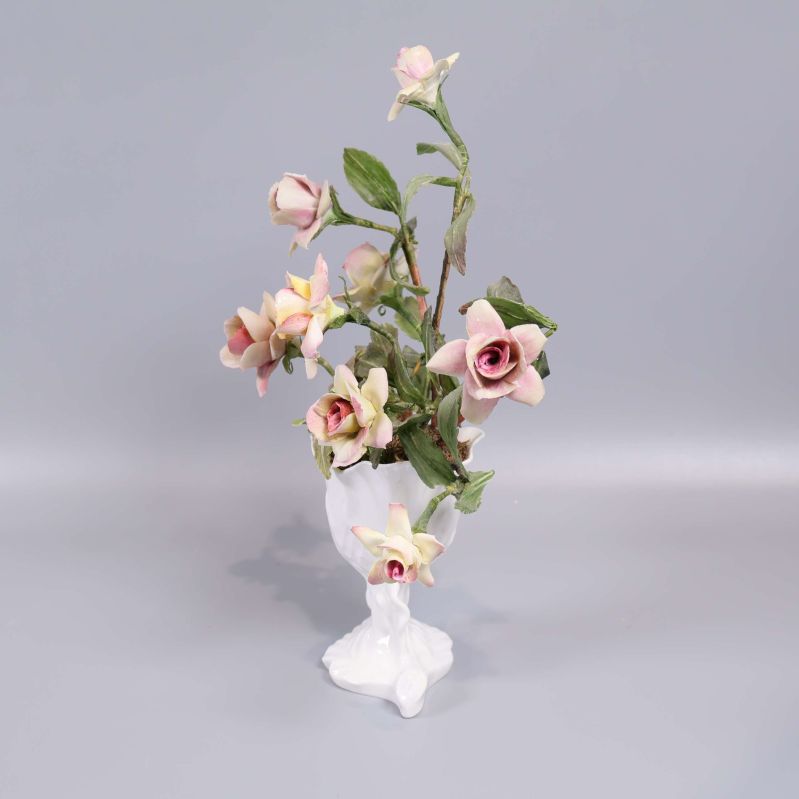 Porslinsvas med konstblommor sedd från sidan
