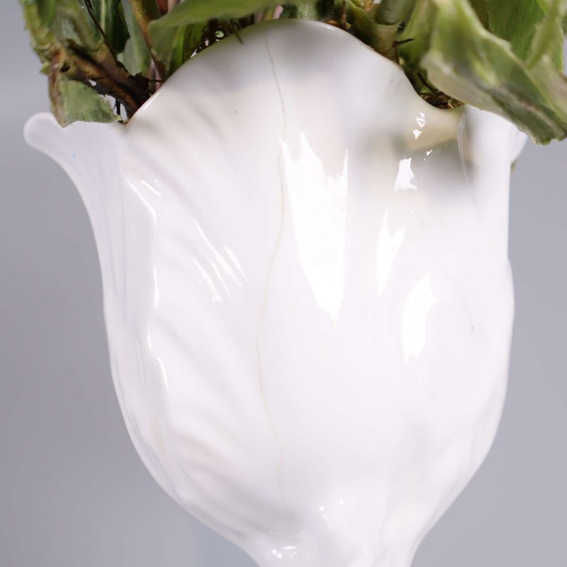 Närbild på vasens vita glaserade yta med spricka